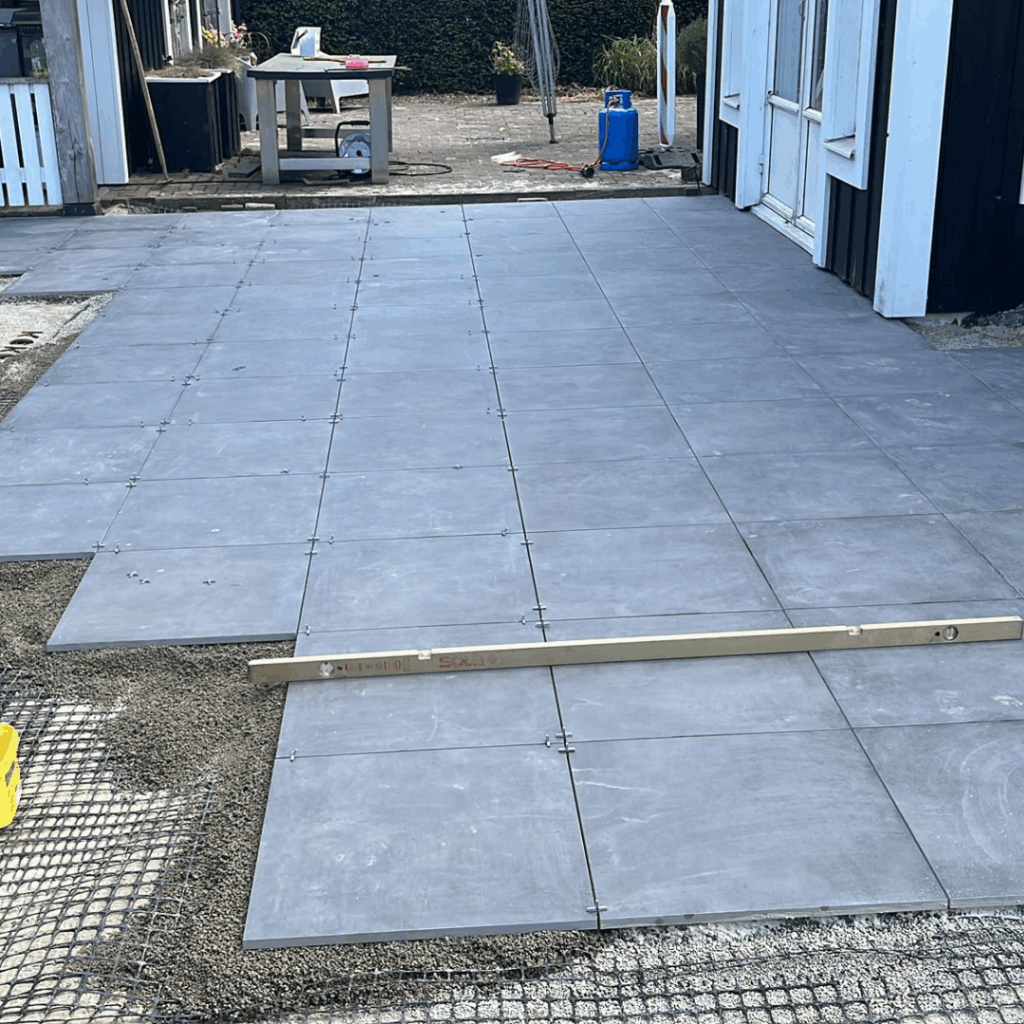 Bestrating: Aanbrengen terras van keramische tegels (in drainagemortel van Romfix, dus geen onkruid en losliggende tegels).