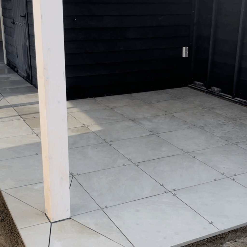 Bestrating: Aanbrengen terras van keramische tegels (in drainagemortel van Romfix, dus geen onkruid en losliggende tegels).